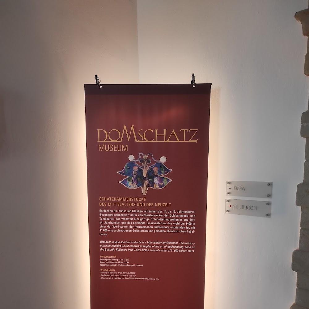 A red poster advertising the Domschatz Museum.